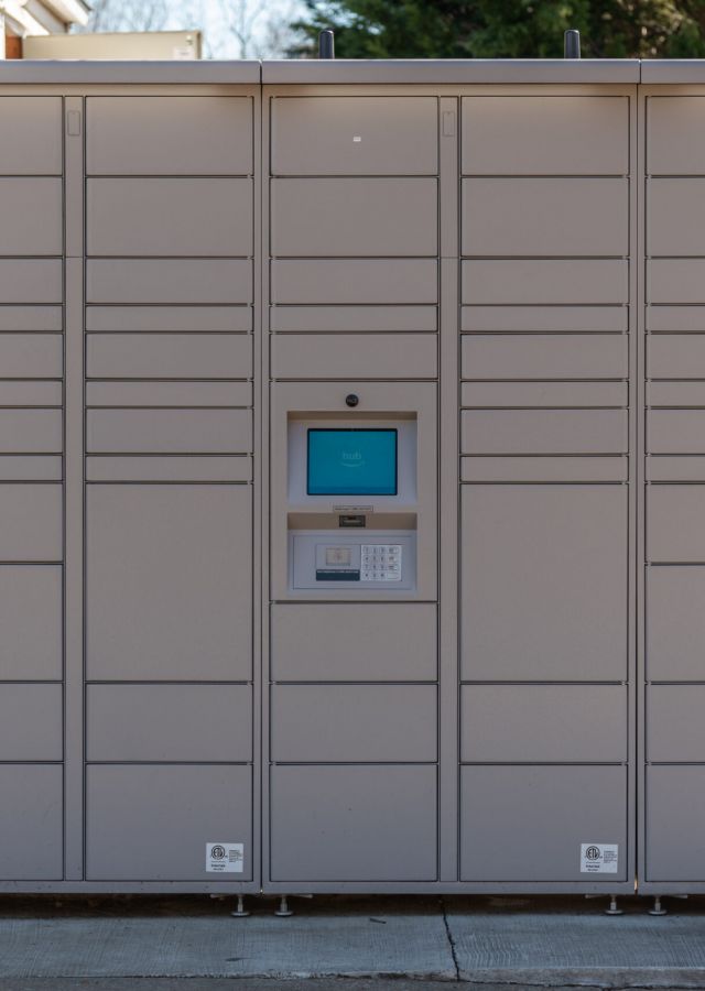 Large outdoor parcel locker system with digital screen and keypad for secure package pickups.